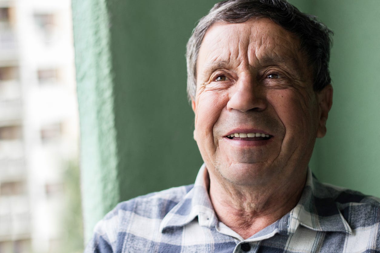 Happy older white man with a smile and frown lines in his forehead.