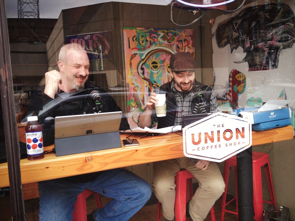 Chris and AJ laughing from the bar by the window over looking the streets of bellingham at the (old) Union Coffee Shop 