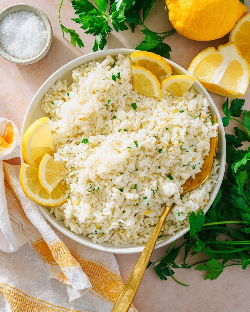Lemon Rice in serving bowl with spoon and lemon slices. Lemon Rice in serving bowl with spoon and lemon slices.