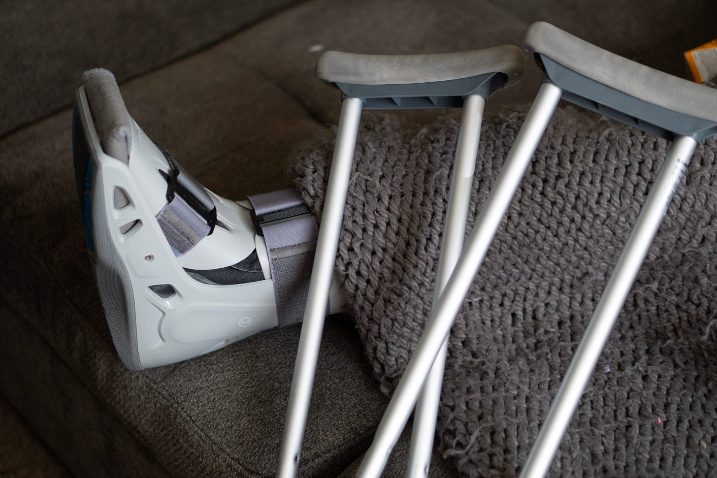 Image showing a foot in a cast with crutches resting over it.