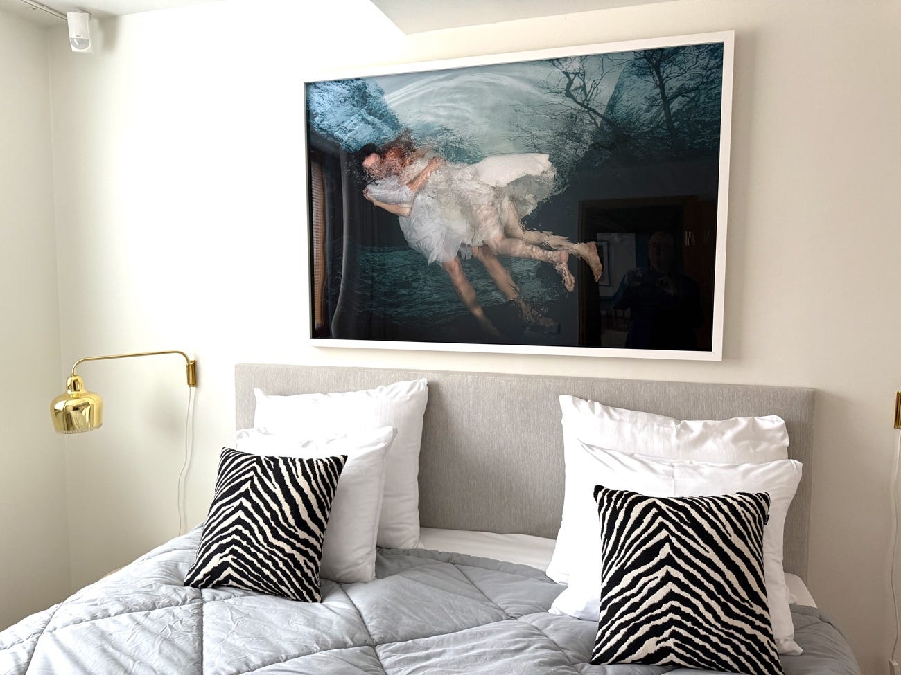A bed with a painting on the wall

AI-generated content may be incorrect.