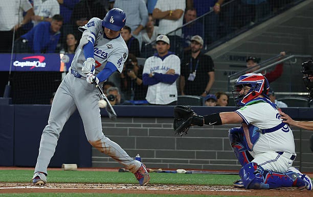 Two-way player Shohei Ohtani of the Los Angeles Dodgers makes contact as the Toronto Blue Jays and the Los Angeles Dodgers play game seven of the MLB...