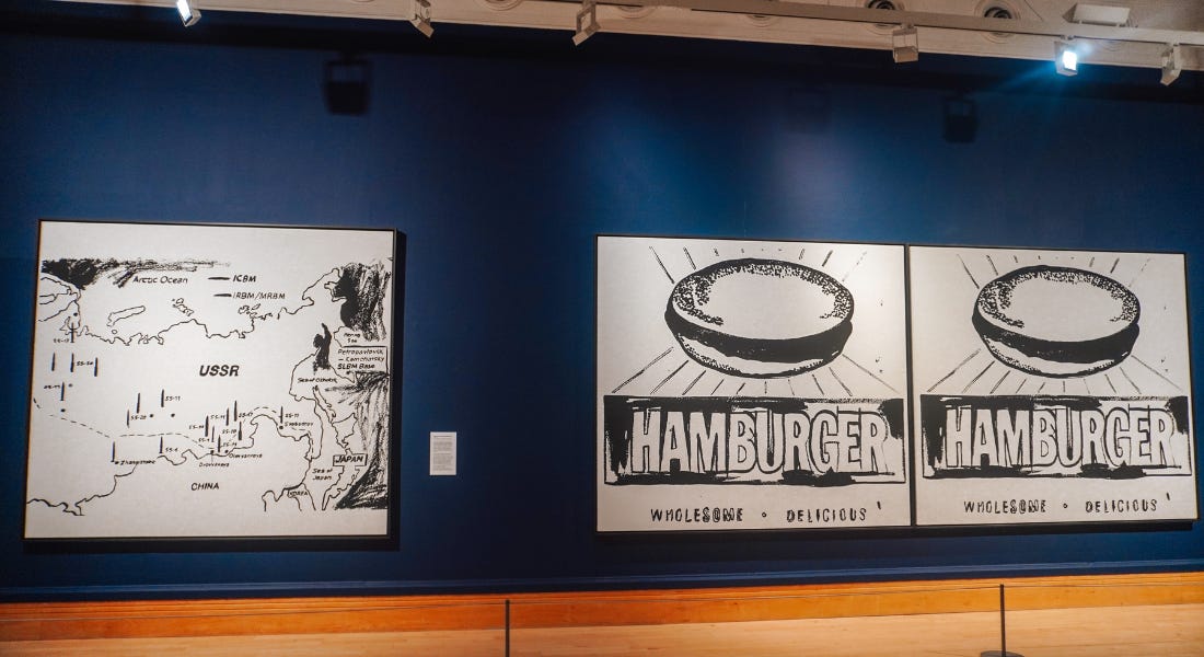 Andy Warhol's USSR map and Hamburger paintings hung up next to each other on a navy blue wall Andy Warhol's USSR map and Hamburger paintings hung up next to each other on a navy blue wall
