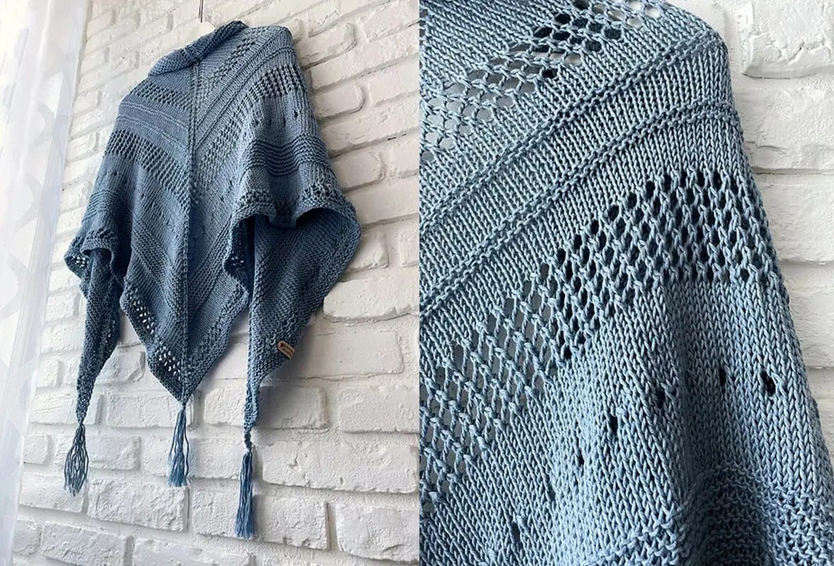 blue lace shawl hanging from a white brick wall