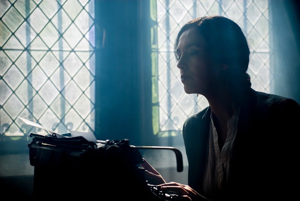 A woman author leans over her typewriter. Image courtesy of Pixabay
