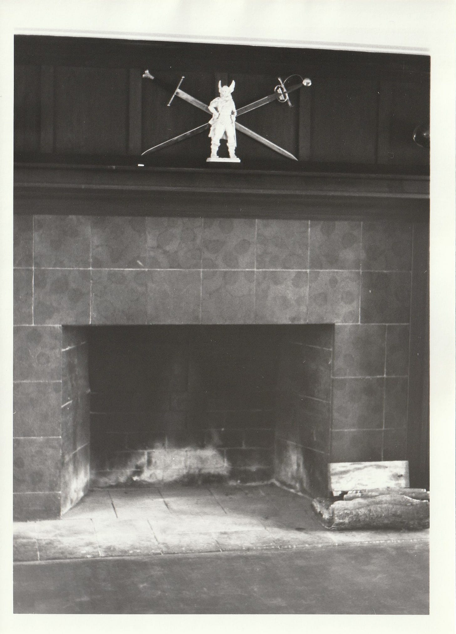 Large fireplace with crossed swords and Viking statue on the mantel
