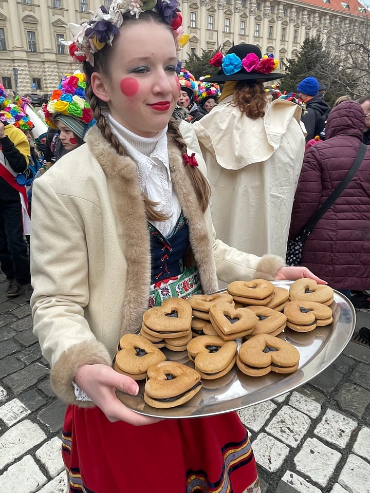 Masopust celebrants in traditional masks and costumes parading through the streets of Prague.