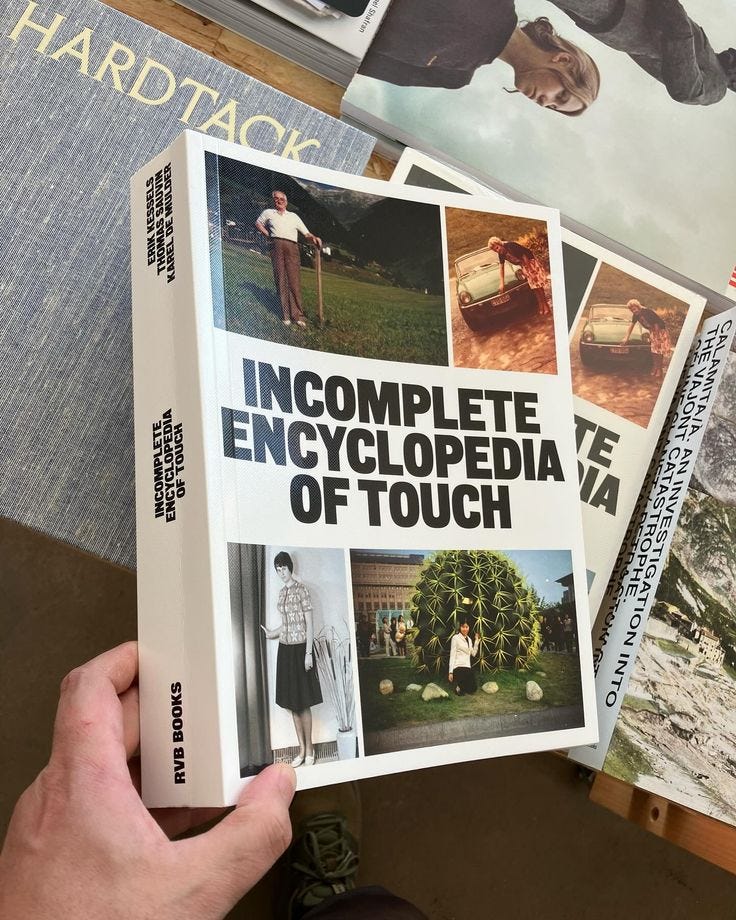 This may contain: a person holding up a book in front of some books on the table with pictures