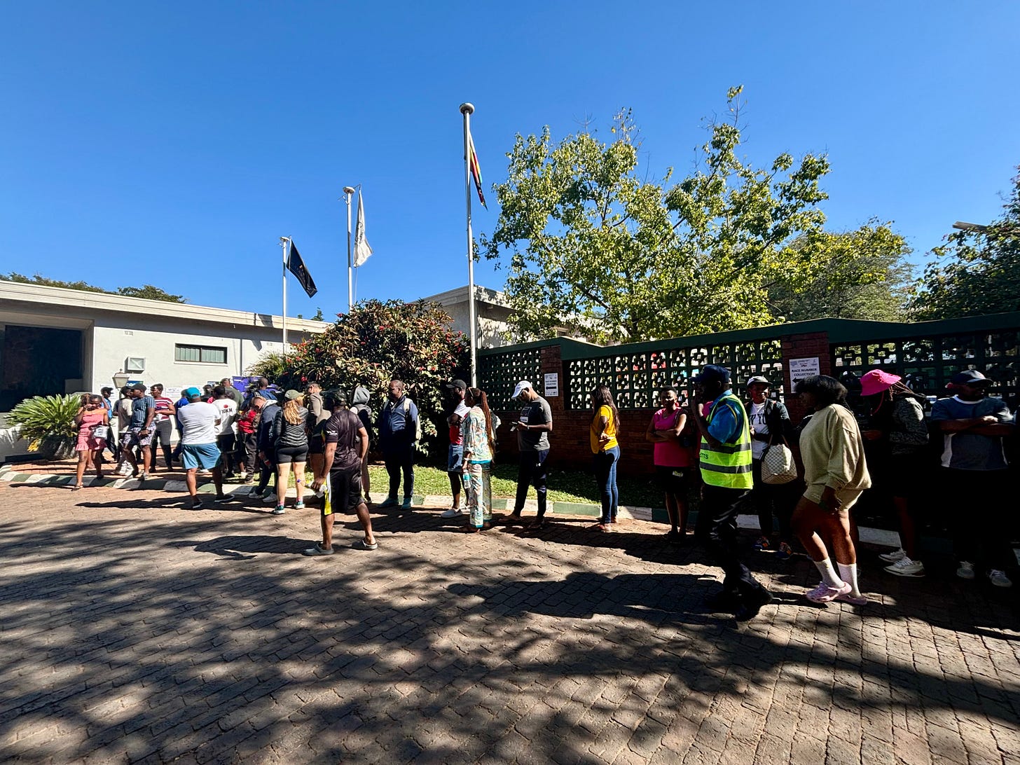 Lining up for packet pick-up at the 2024 Victoria Falls Marathon event. Participants in the race travel program can pick up their packets at their hotel front desk. Lining up for packet pick-up at the 2024 Victoria Falls Marathon event. Participants in the race travel program can pick up their packets at their hotel front desk.