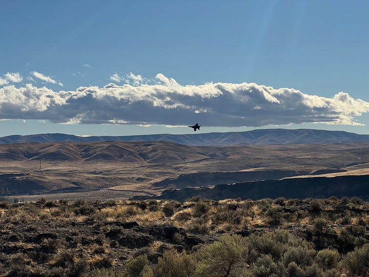 Four images, top left fighter jet flys over Columbia River Gorge. Top right: Hidden Lake with mountain in background and pine trees in foreground. Bottom left, river surrounded by rocks and pine trees, mountain in the background. Bottom right, pine trees in foreground with a river and train tracks snaking their way through the middle. Mountain range in the distance.