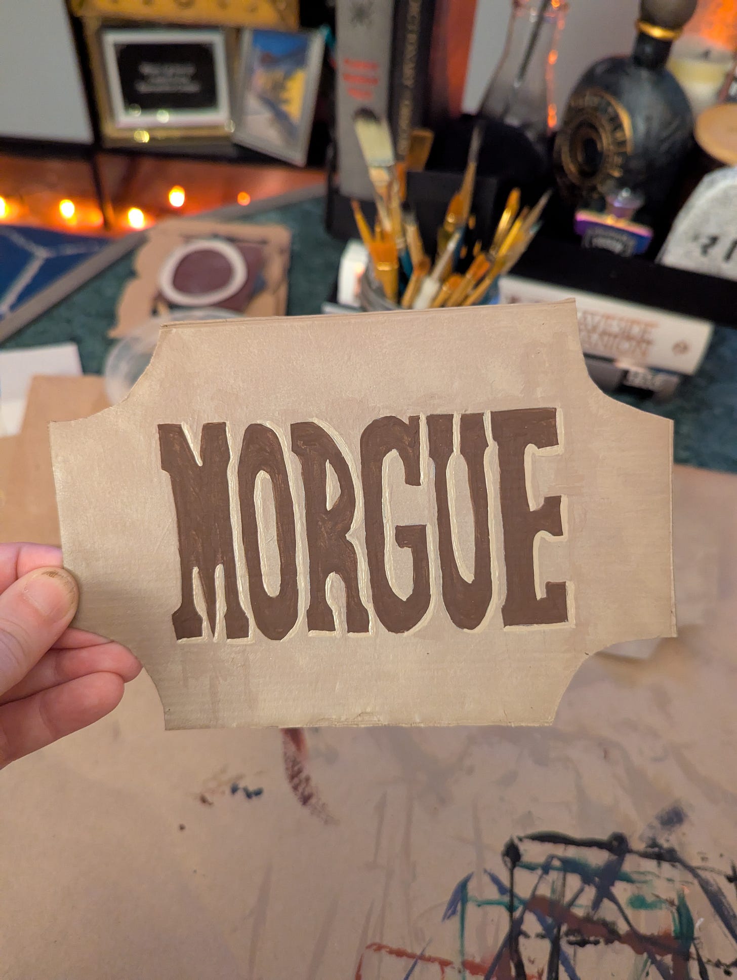 handpainted sign out of cardboard that reads MORGUE in brown wild west style font