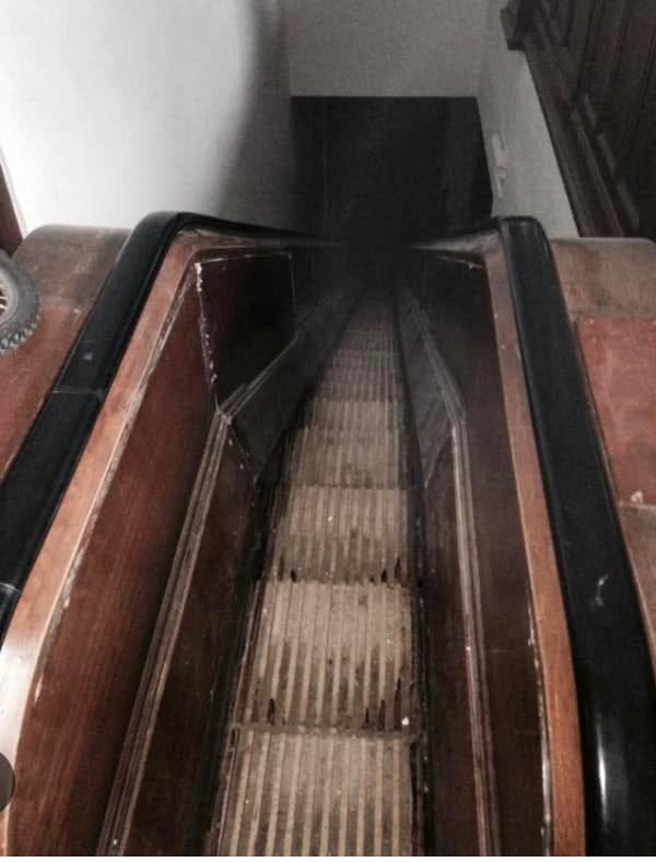 A photo looking down at a wooden escalator.
