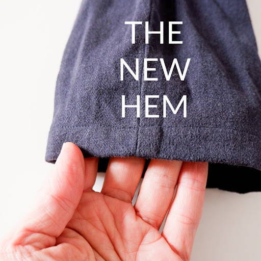 hand showing a newly sewn hem of pants that were shortened