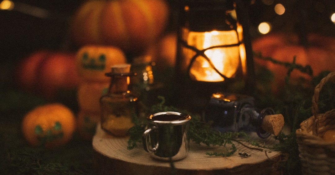A table topped with lots of pumpkins and a lantern