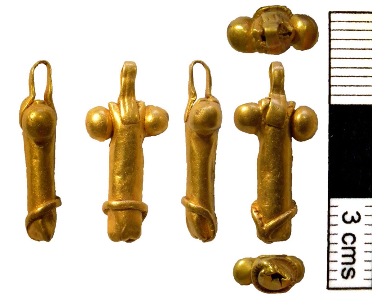 A gold penis amulet photographed from various angles A gold penis amulet photographed from various angles