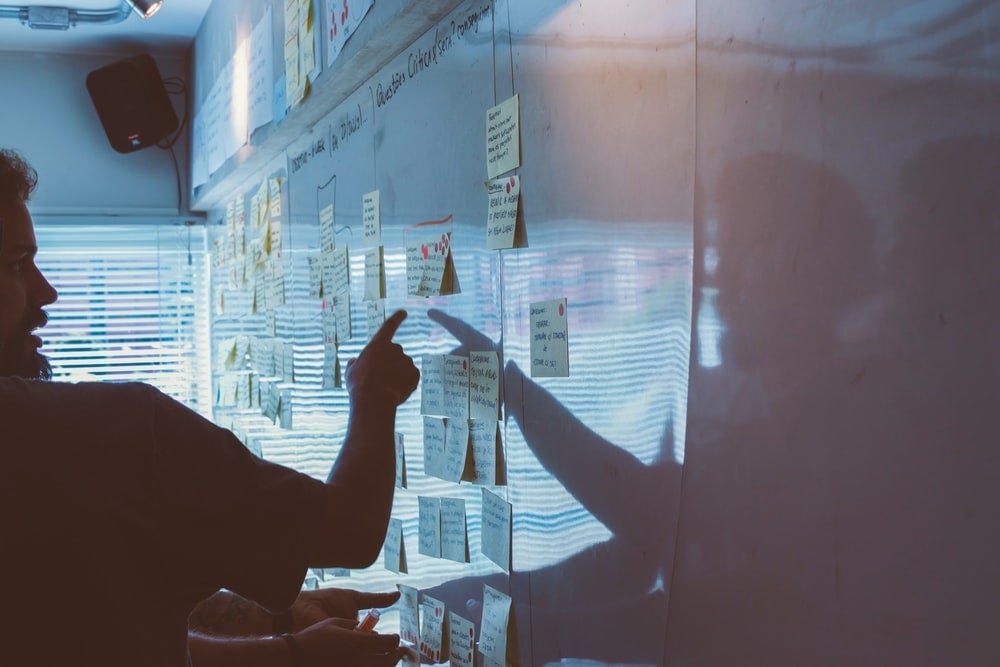 person pointing white paper on wall person pointing white paper on wall