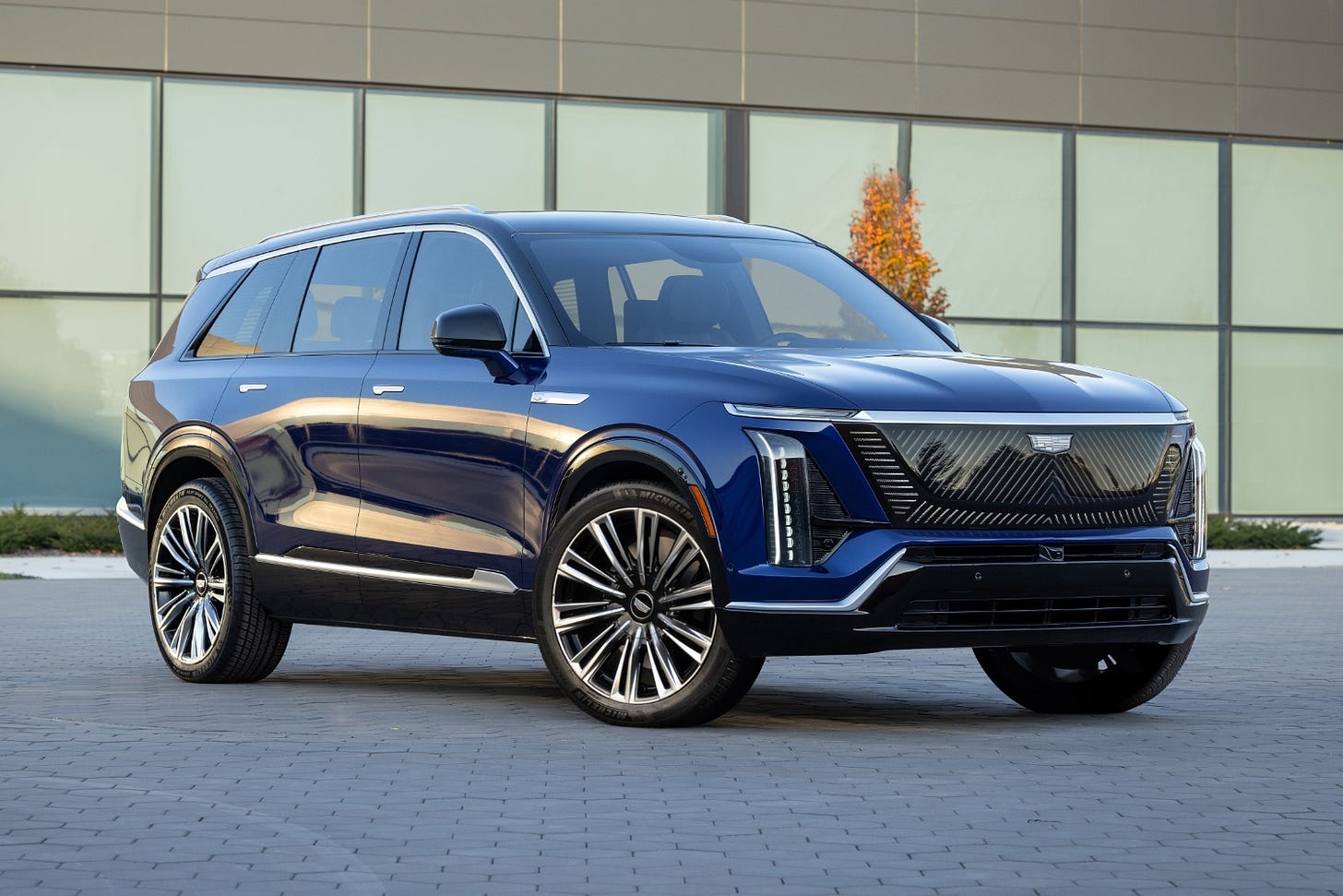 A dark blue 2026 Cadillac Vistiq parked in a courtyard showing the front quarter view.