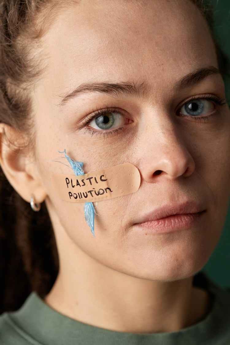 woman with a band aid on her cheek saying plastic pollution