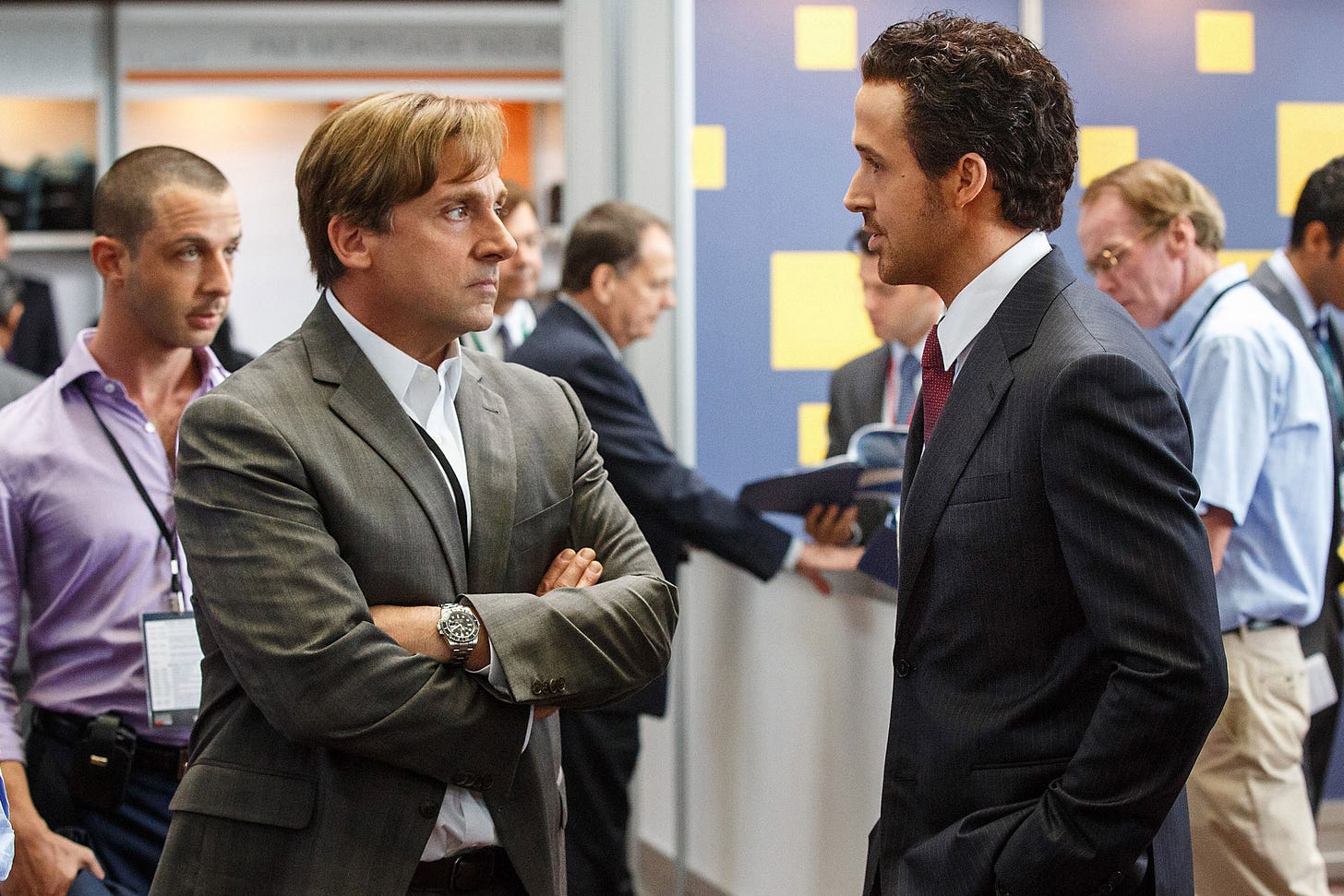 From The Big Short: Steve Carrel crosses his arms and looks perturbed at Ryan Gosling, who looks like he's got a golden ticket. From The Big Short: Steve Carrel crosses his arms and looks perturbed at Ryan Gosling, who looks like he's got a golden ticket.