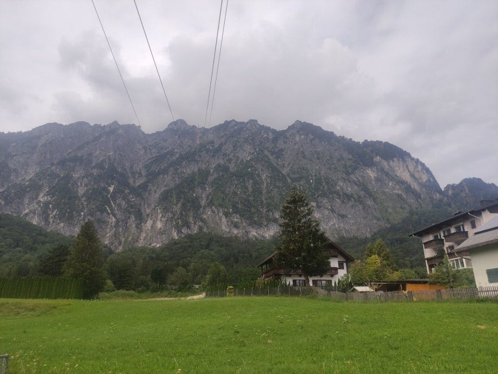 View of the Untersberg mountain from below, With cables disappearing toward the mountain, appearing to not rise toward the peak.