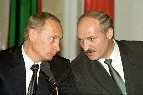 This may contain: two men in suits and ties are facing each other while one man is speaking into a microphone This may contain: two men in suits and ties are facing each other while one man is speaking into a microphone