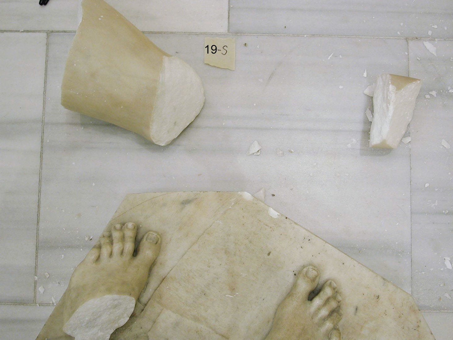 Fragments of Tullio Lombardo's Adam on a marble floor.