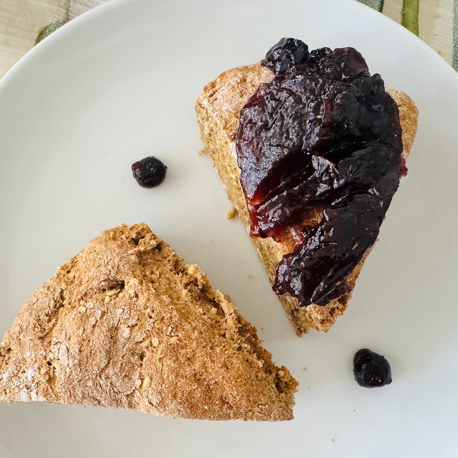 Irish wholemeal brown bread, golden and dense, sliced, plated, slathered in blackberry jam, and served at the table.