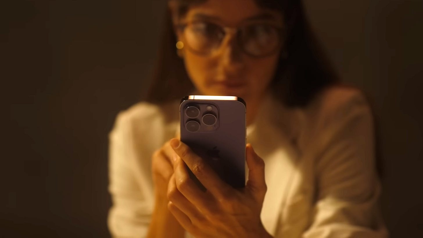A woman holding an iPhone 14