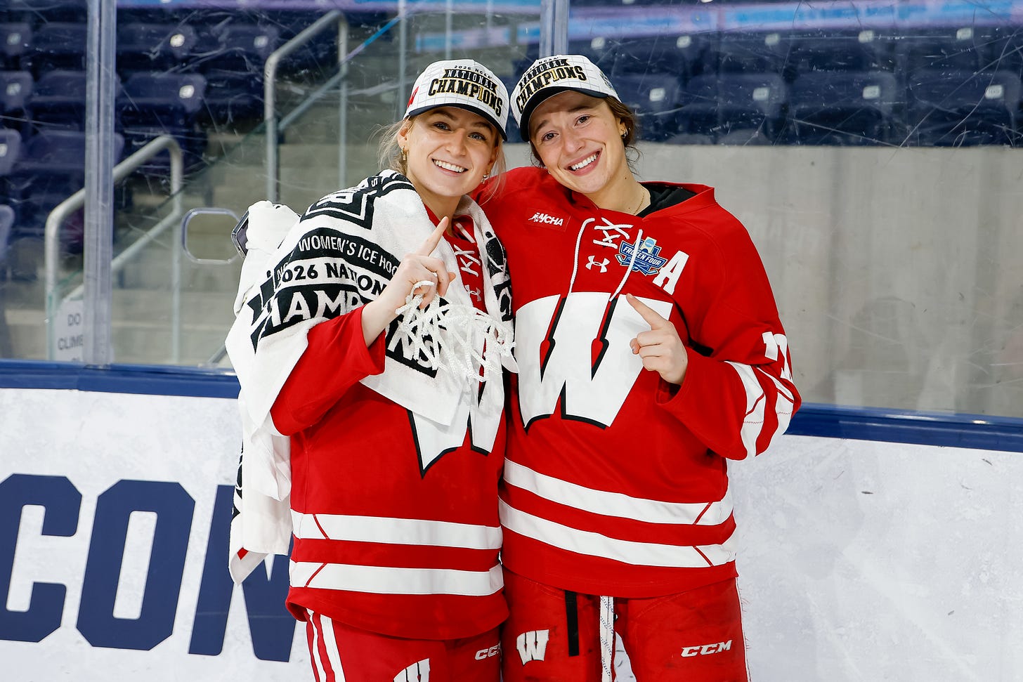 Wisconsin women's hockey forwards Claire Enright and Marianne Picard on ice after the title game wearing national champion hats
