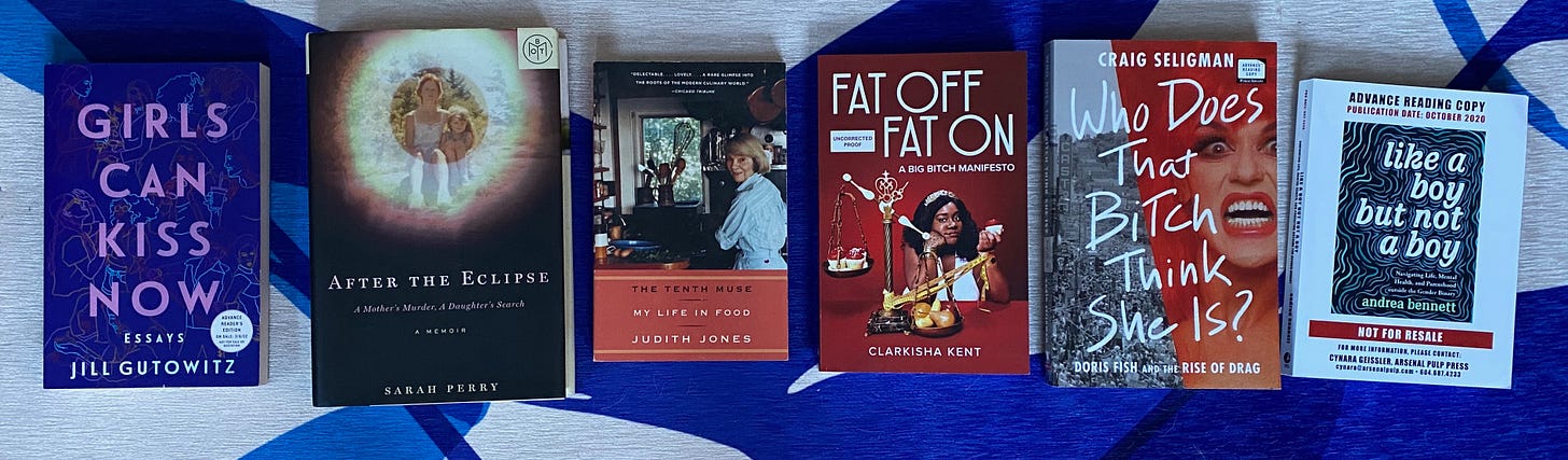 The listed books spread out in a row on a blue and white rug.