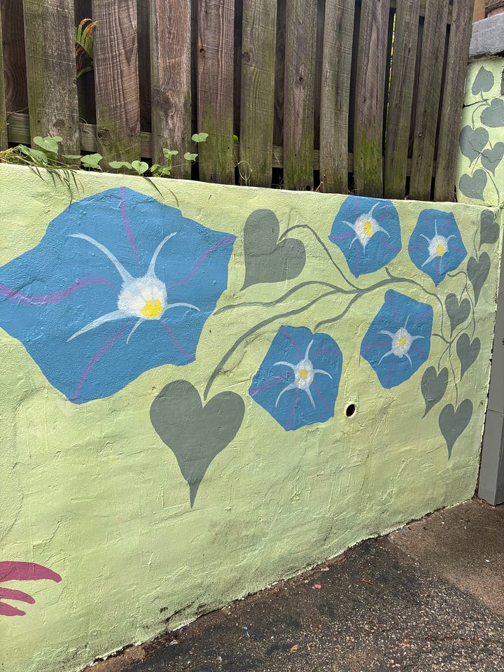 Four photographs of a mural in progress. Giant morning glory and echinacea blossoms on a light green background.