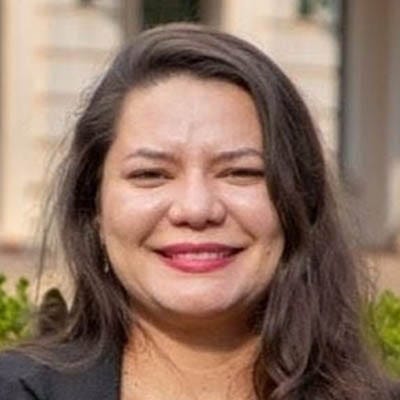 Mulher branca, cabelo à altura do ombro, sorridente