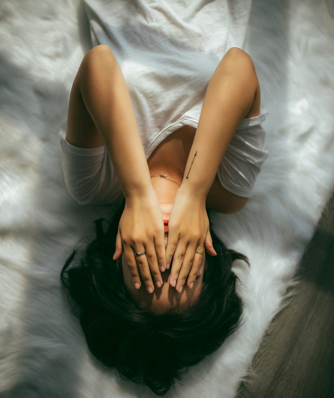 a woman holds her hands over her face