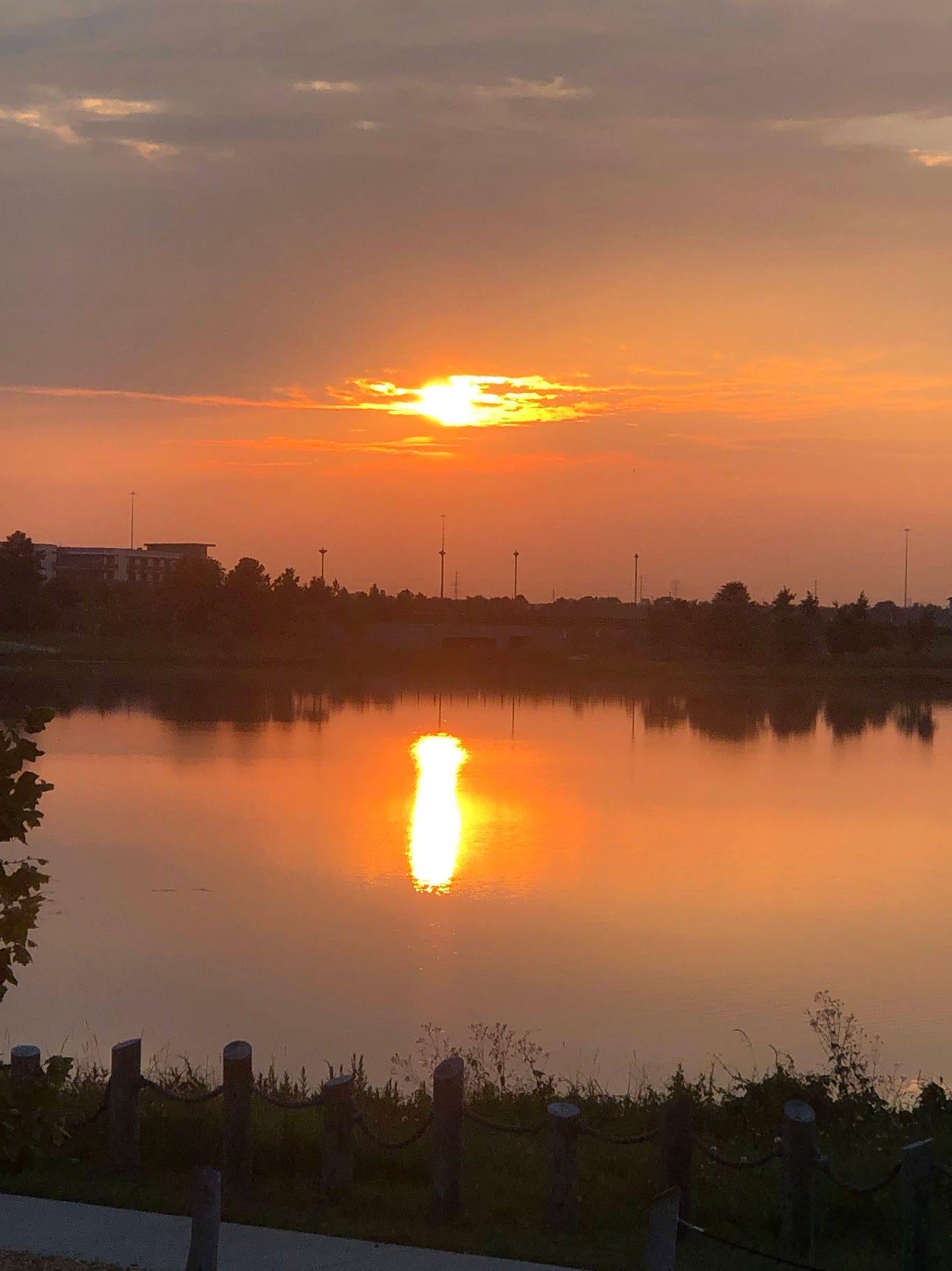 a photo of a red-orange sunset over a lake.