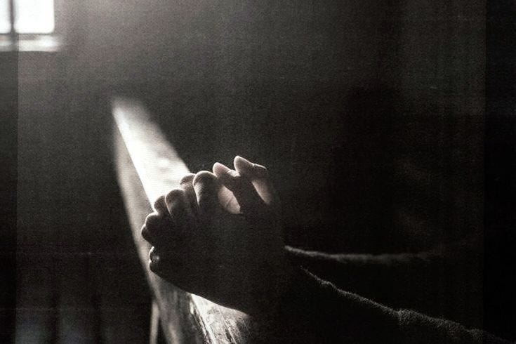 This may contain: a person's hand resting on the edge of a bench in a dark room