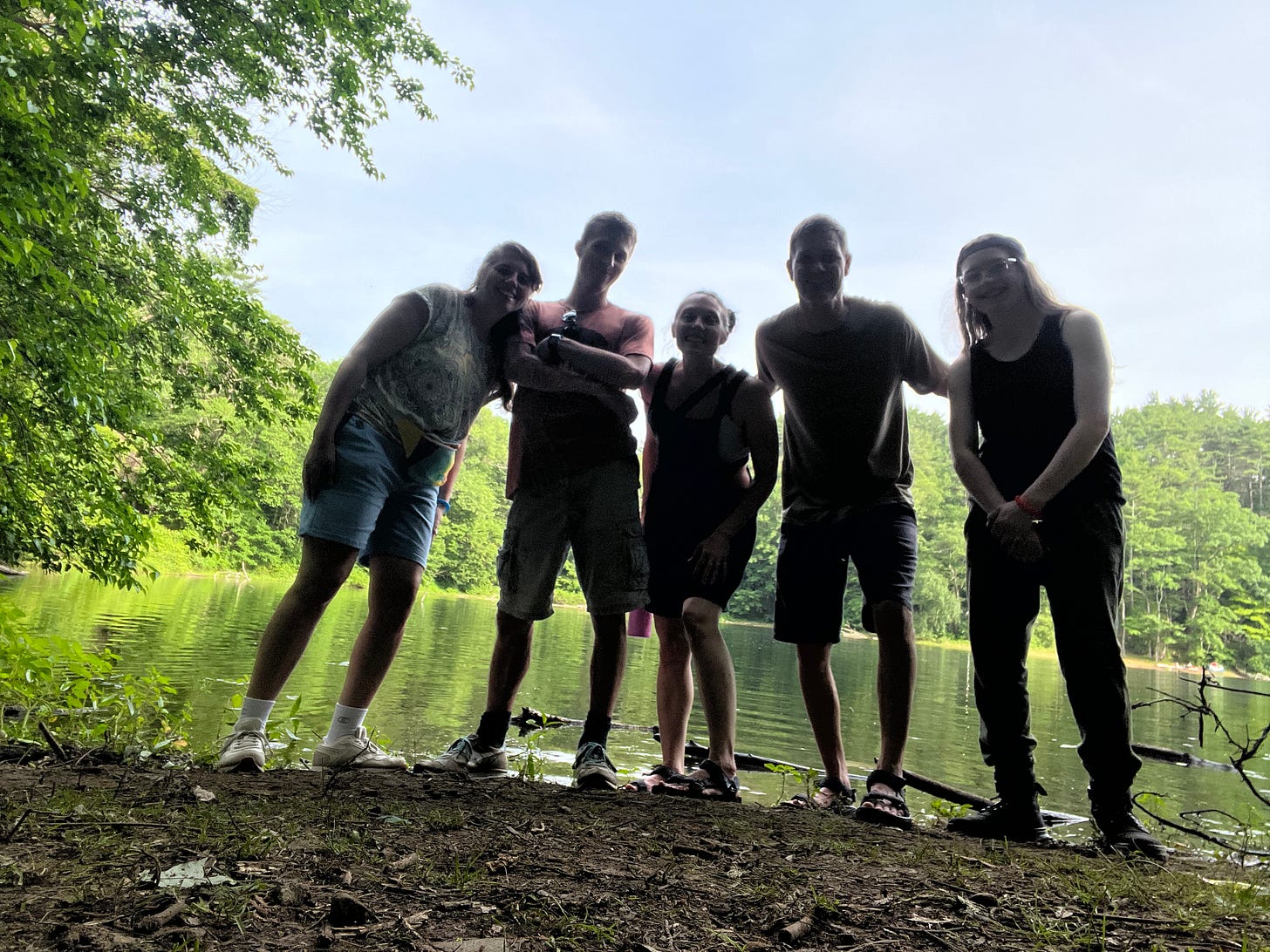 Photo of five people standing in front of a lake.