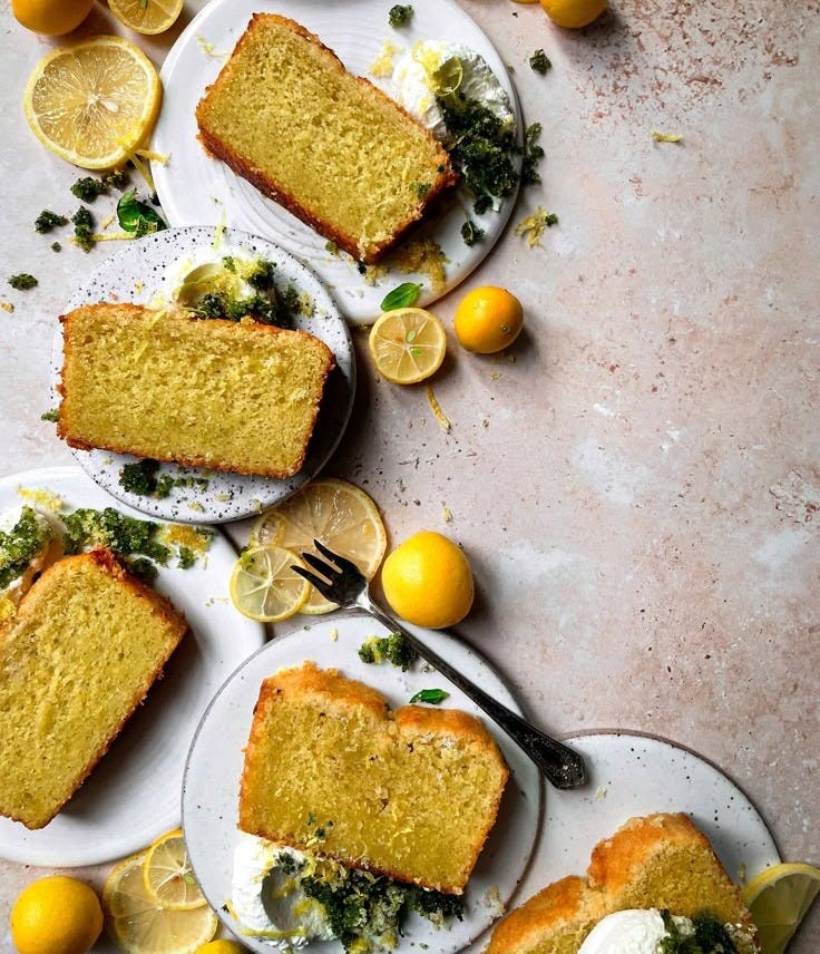This may contain: slices of lemon cake on plates with forks and lemons scattered around the plate,