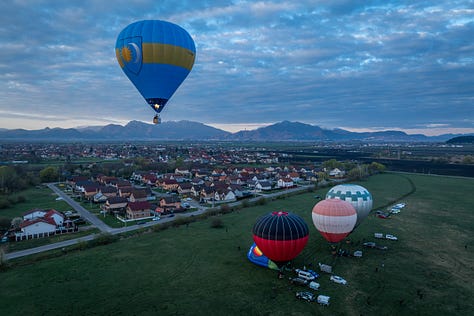 Există ceva profund omenesc în balonul cu aer cald. Balonul nu rupe aerul. Nu îl sfâșie cu viteză. Se ridică lent, aproape cu sfială, și tocmai de aceea pare atât de aproape de ideea de vis.