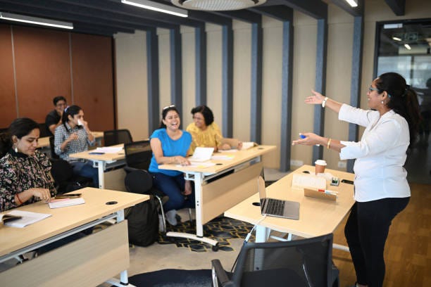 Female Instructor teaching mature adult students in the classroom stock photo