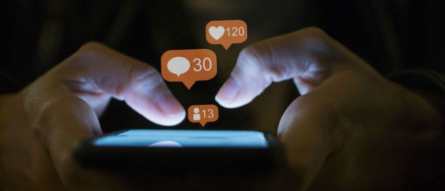 A person holds a smart phone and the following are jumping off the page: 120 likes, 30 comments, 13 friend requests