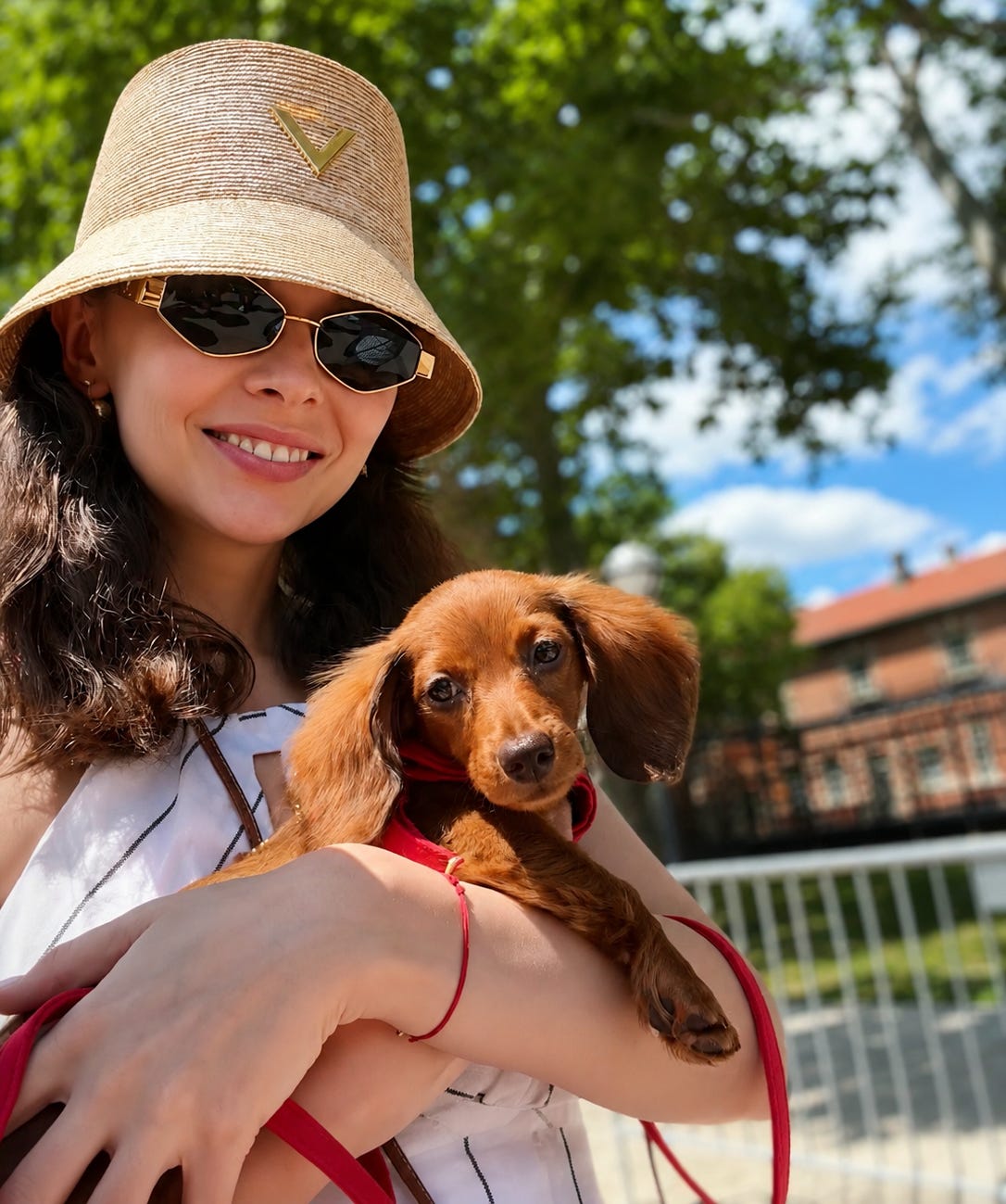 Iana walking in the sun with her miniature dachshund puppy Iana walking in the sun with her miniature dachshund puppy