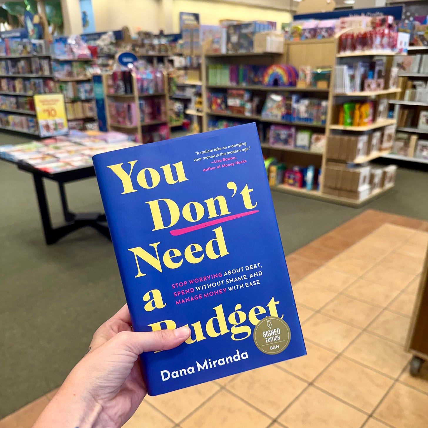 a hand holds a copy of YDNAB in a bookstore a hand holds a copy of YDNAB in a bookstore