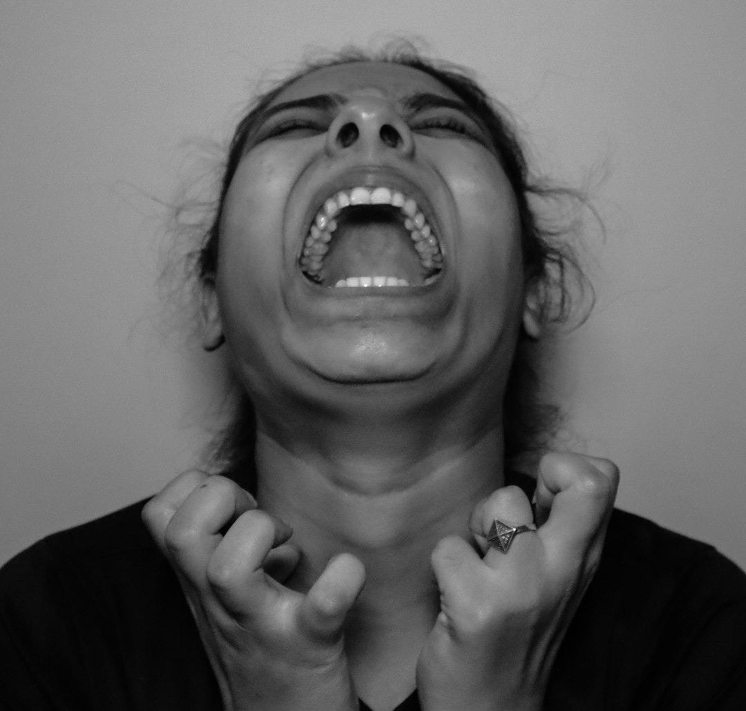 a woman with her mouth open and hands in front of her face
