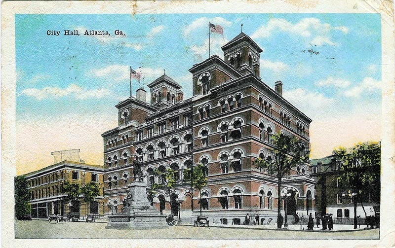 Grand four-story building with turrets with statue of Henry Grady facing it Grand four-story building with turrets with statue of Henry Grady facing it