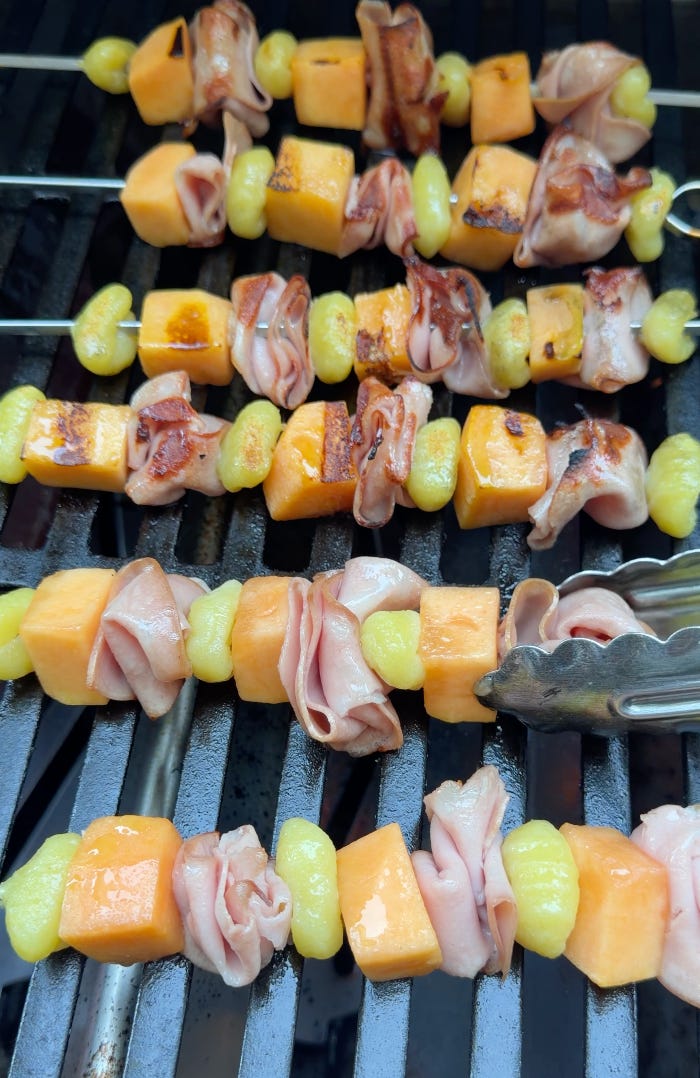 Mortadella, cantaloupe, and gnocchi skewers grilling on a BBQ grill before and after charring