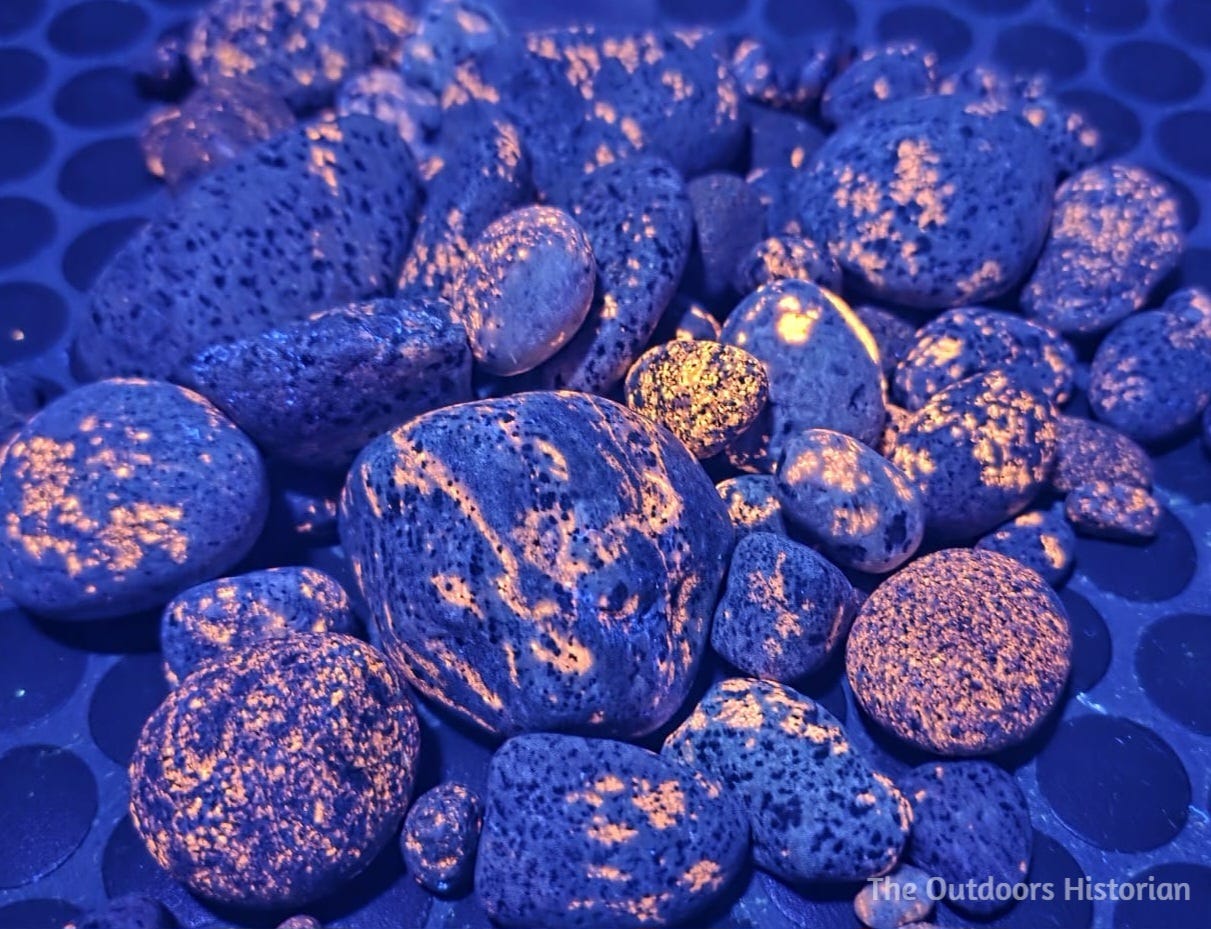 A pile of rocks that are glowing orange under a UV light.