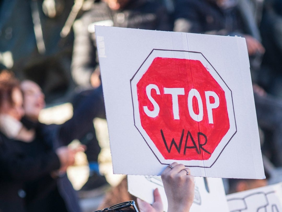 a woman wearing a face mask holding a stop sign