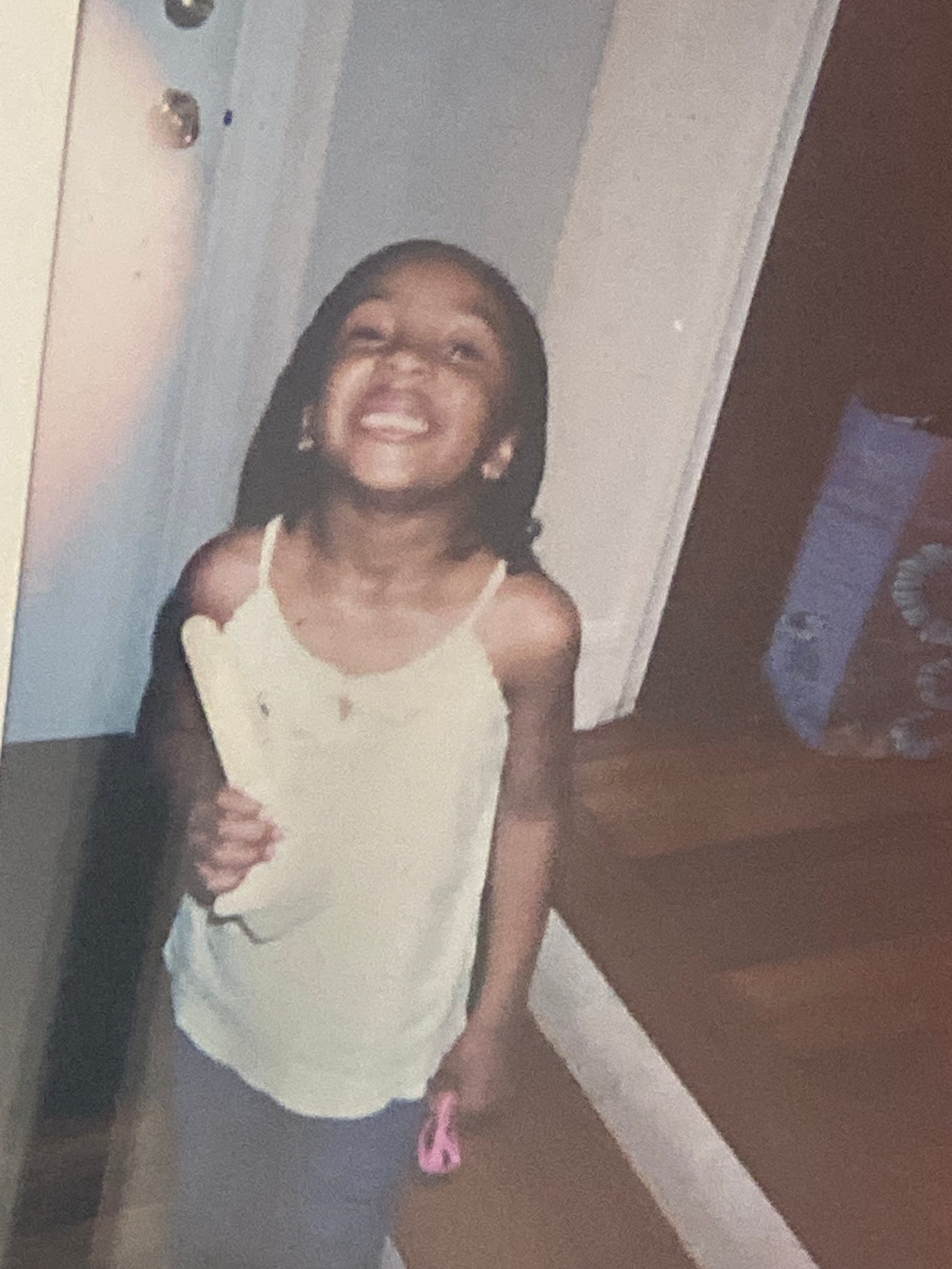 An image of me smiling widely after losing my first tooth as a child.