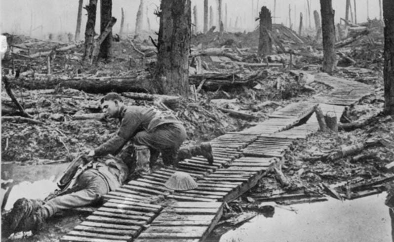 Soldier turns over dead comrade after battle amidst devastation