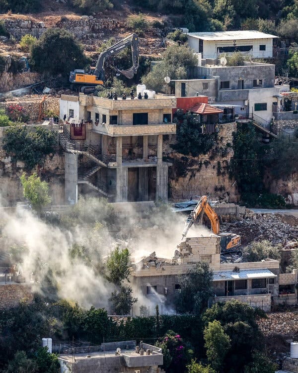 Houses and construction vehicles at work on them.